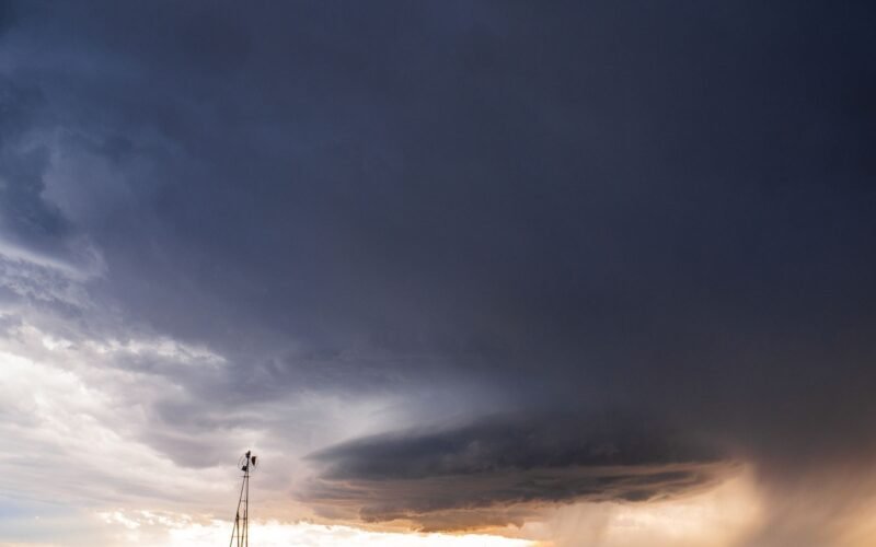Dark storm clouds building over open grassland plains.