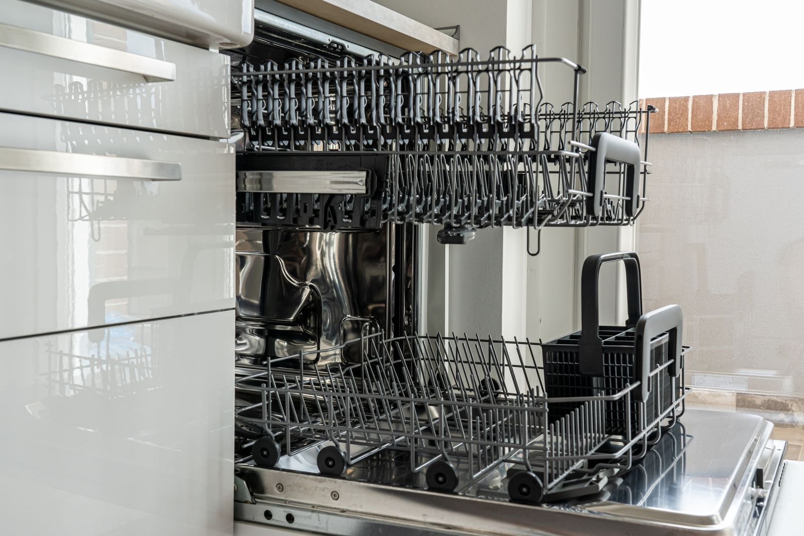 Kitchen floor with water leaking from under a dishwasher