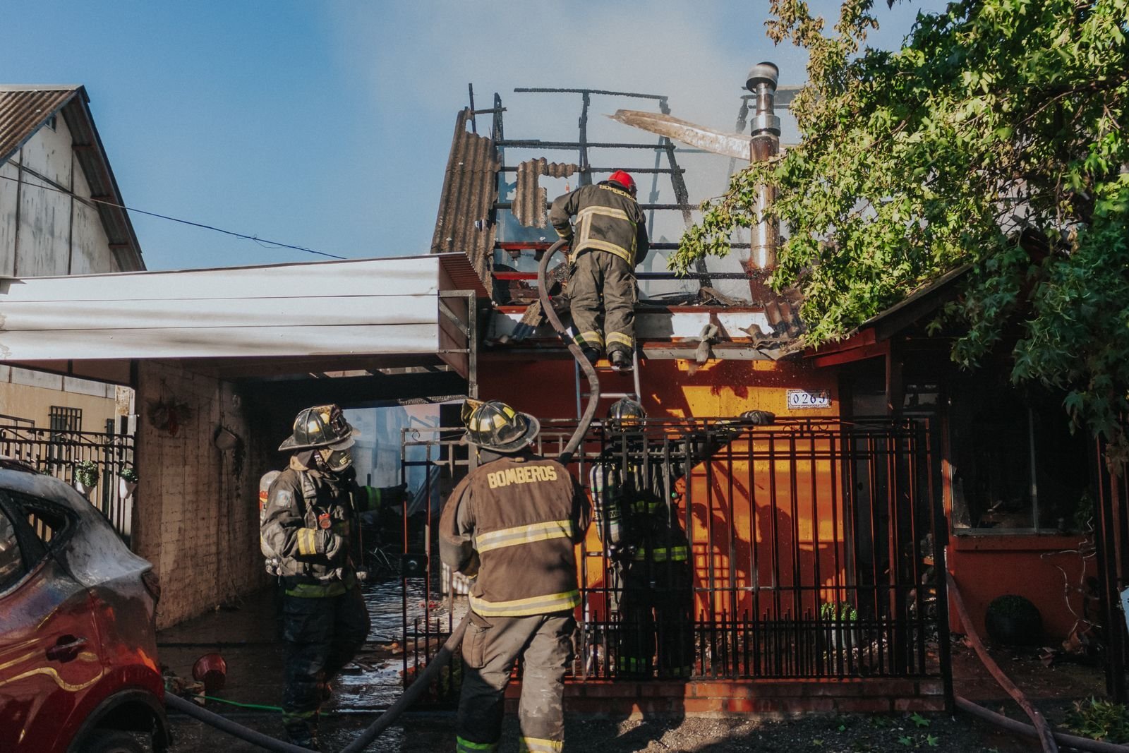 Firefighters working at a house fire with heavy smoke