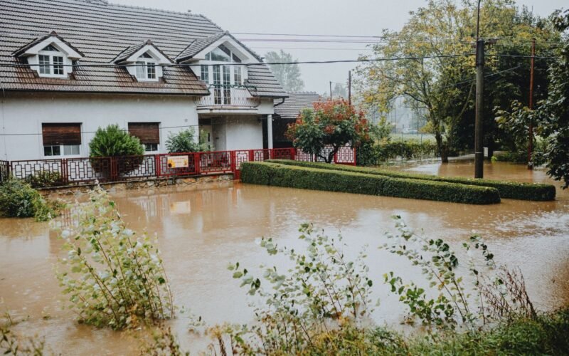 Suburban house surrounded by floodwater after heavy rain.