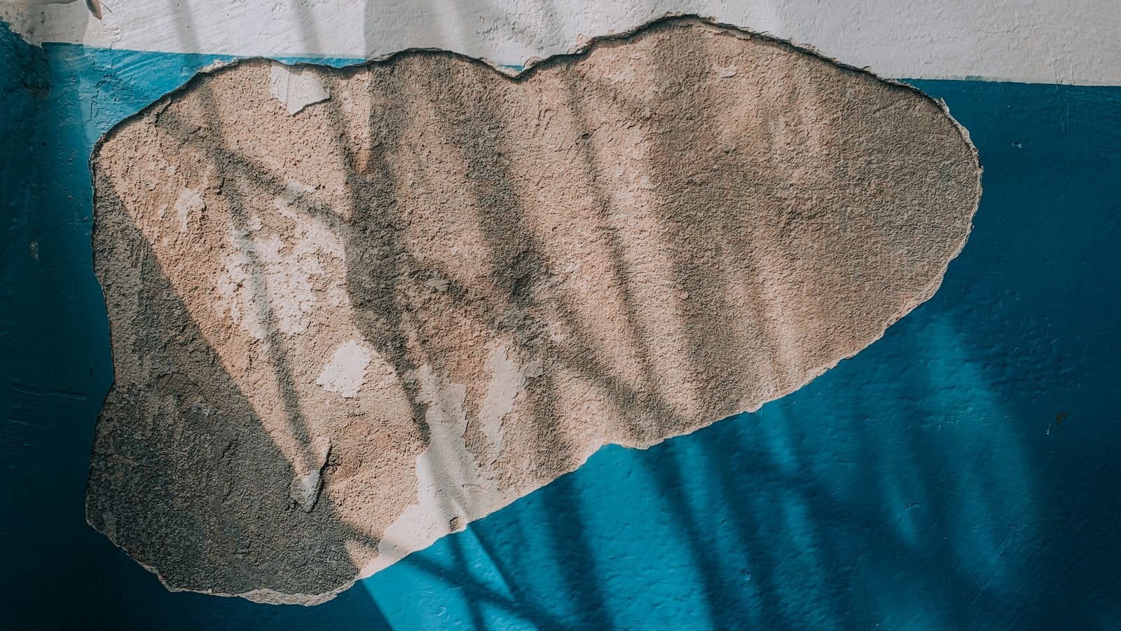 Interior wall with peeling paint and damaged plaster from a water leak